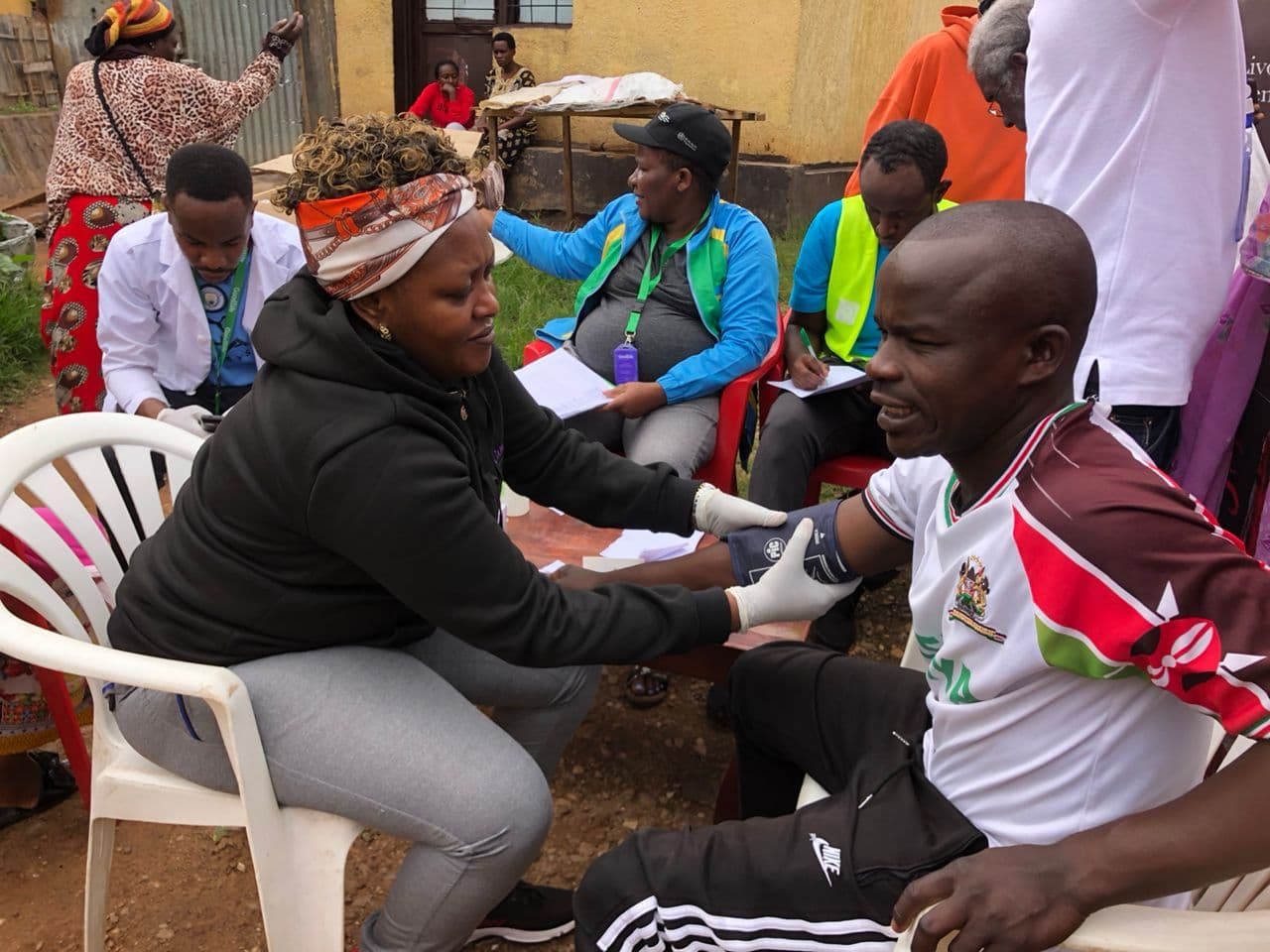 A Goodlife health worker takes a man's blood pressure at a community screening event.