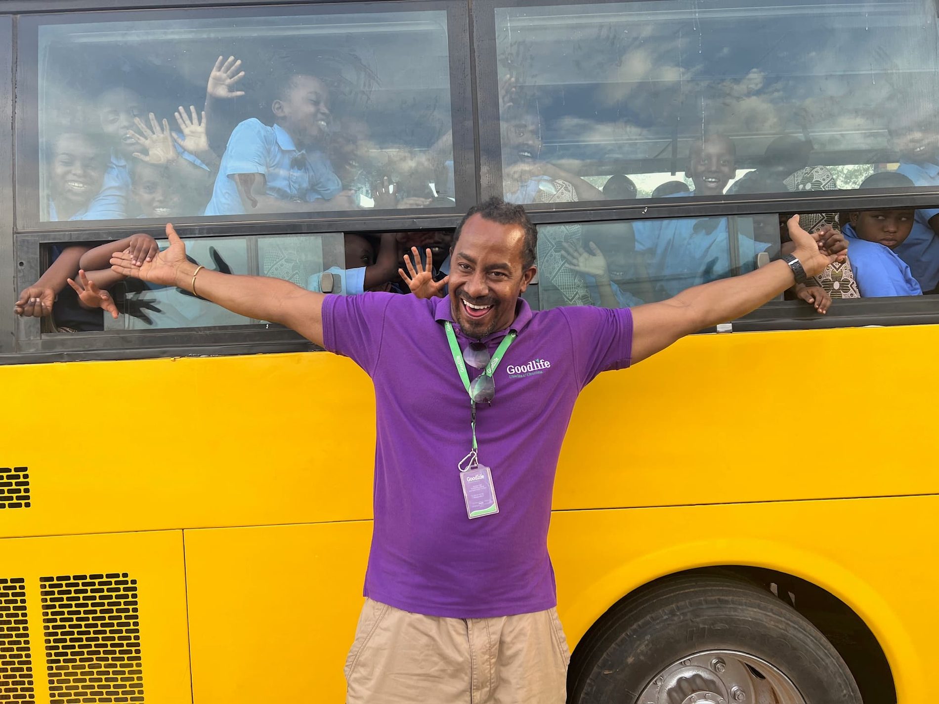A Goodlife team member greeting schoolchildren on an outreach bus in Rwanda.